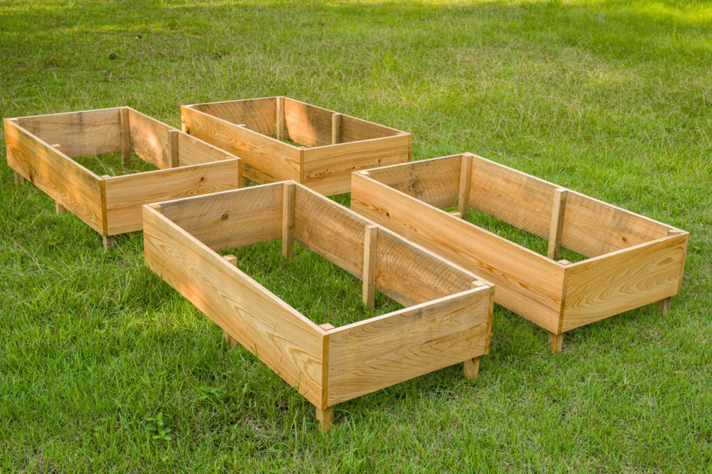four DIY Raised Garden Beds sitting in the grass 