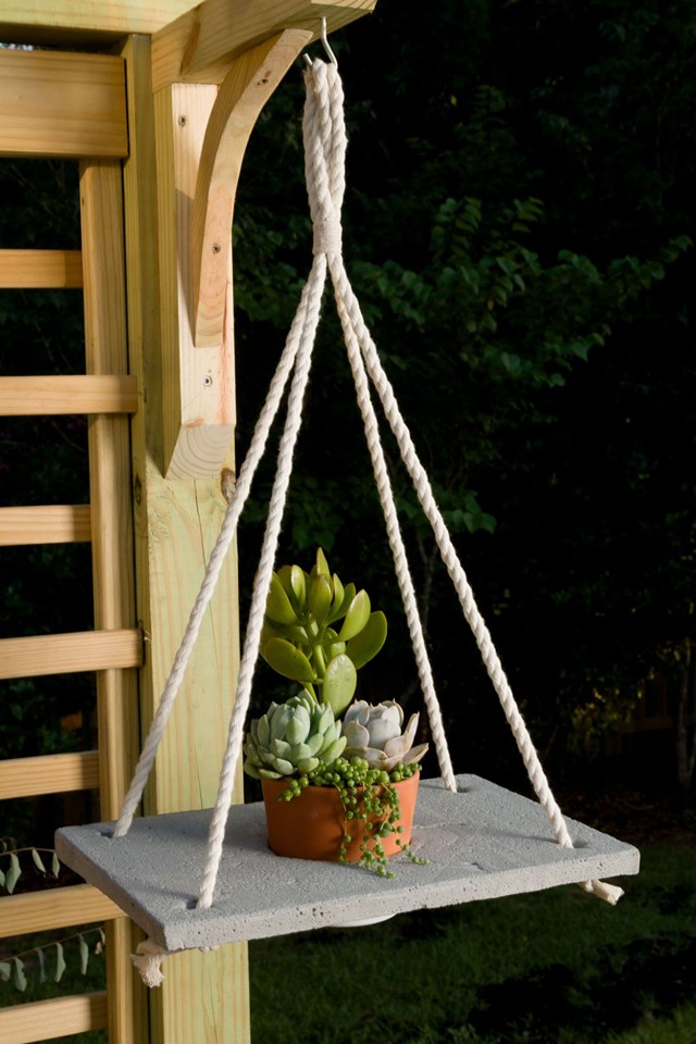 Boho hanging planter with succulents hanging from a wood trellis