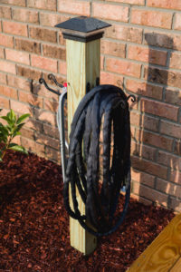 Closeup of completed garden hose storage post with solar light