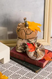 Cozy rustic decor with wood antique books and Goodwill skirt pumpkins