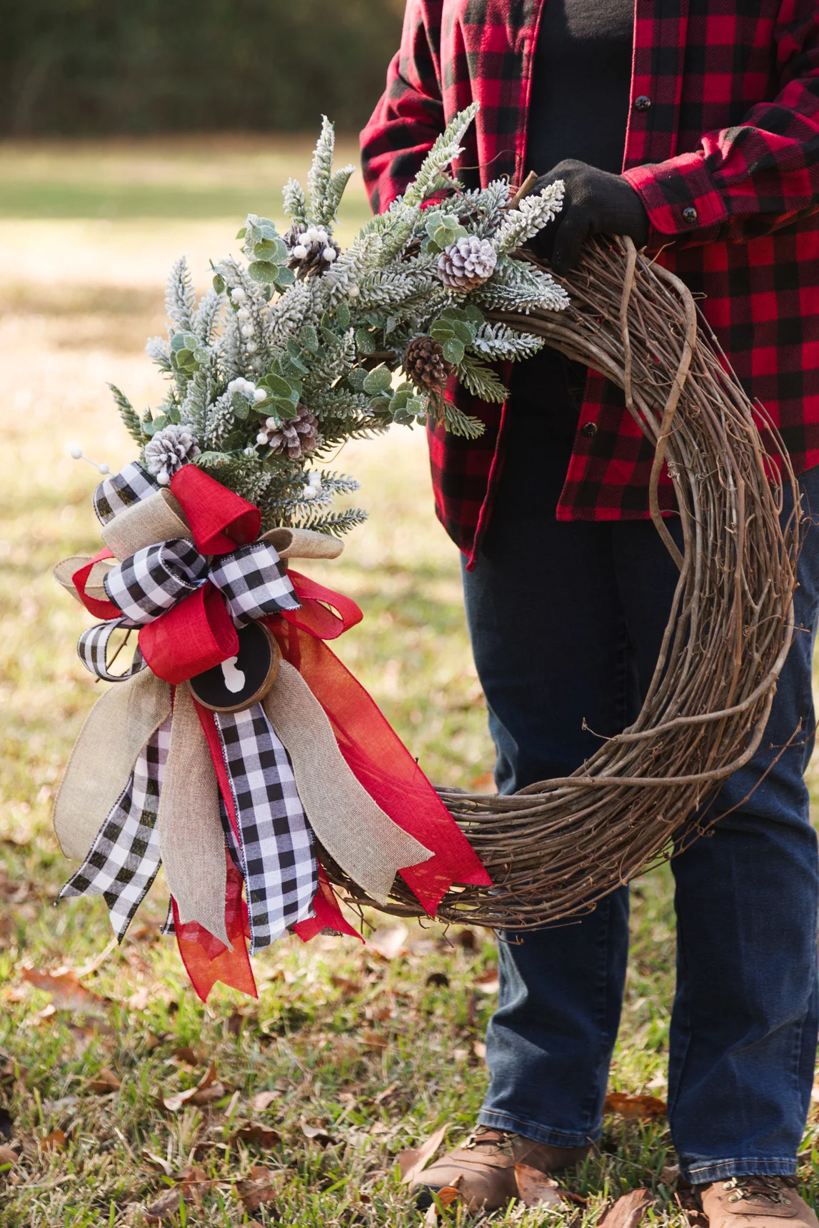 DIY Christmas wreath and ribbon bow being held outside