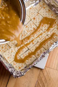 Pouring the brown sugar and butter mixture over crackers