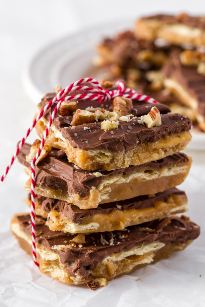 Christmas Crack cookies stacked on top of each other and tied up with red and white baker's twine