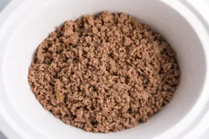 Cooked Ground beef in a white Crockpot
