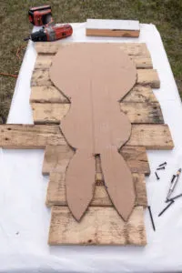 Reclaimed pallet wood cut into pieces with the bunny template placed over the wood