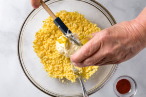 Adding mustard to yolk mixture