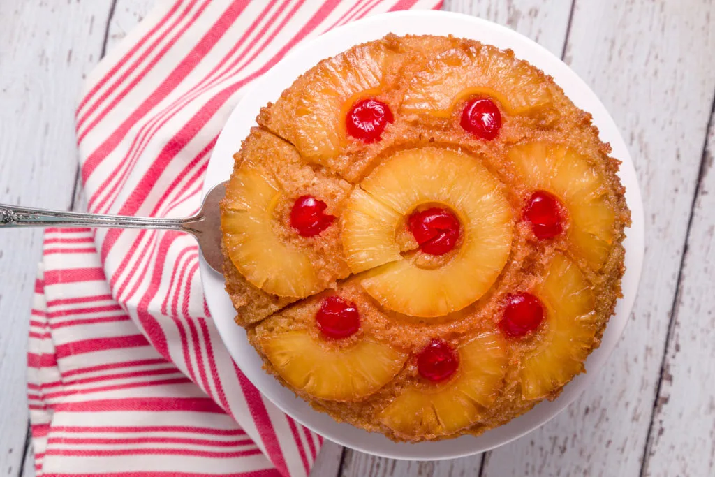 Pineapple Upside-Down Cake with a slice cut out on a cake server