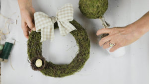 Attach the checked ribbon bow to the moss wreath 
