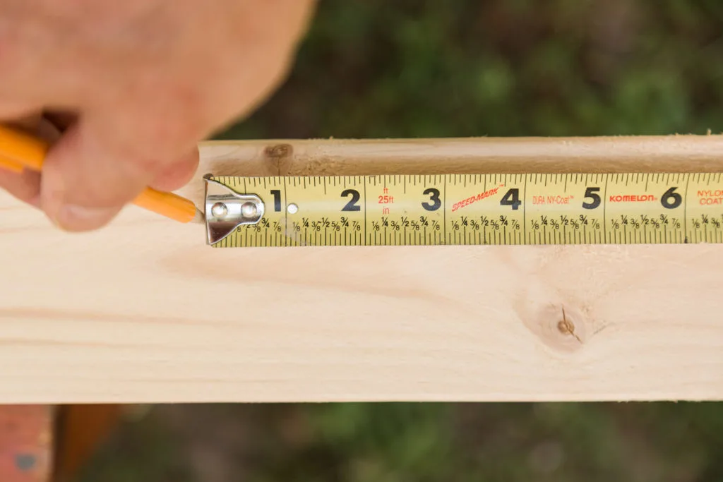 Measure lumber for coat hooks and mark with a pencil
