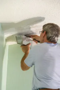 Scraping the popcorn ceiling off with a putty knife