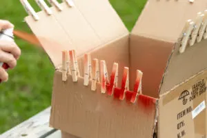 Spray painting the clothespins red
