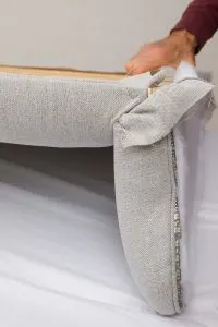Positioning the wing against the center portion of the headboard.