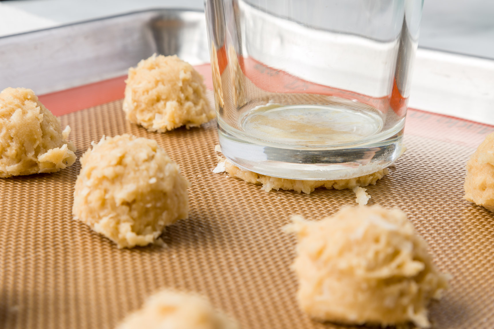 Flatten coconut cookies with a glass