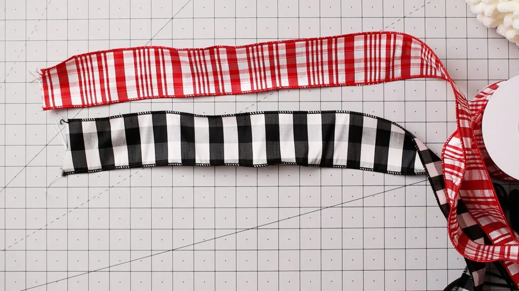 Red and white plus black and white ribbon on a craft mat