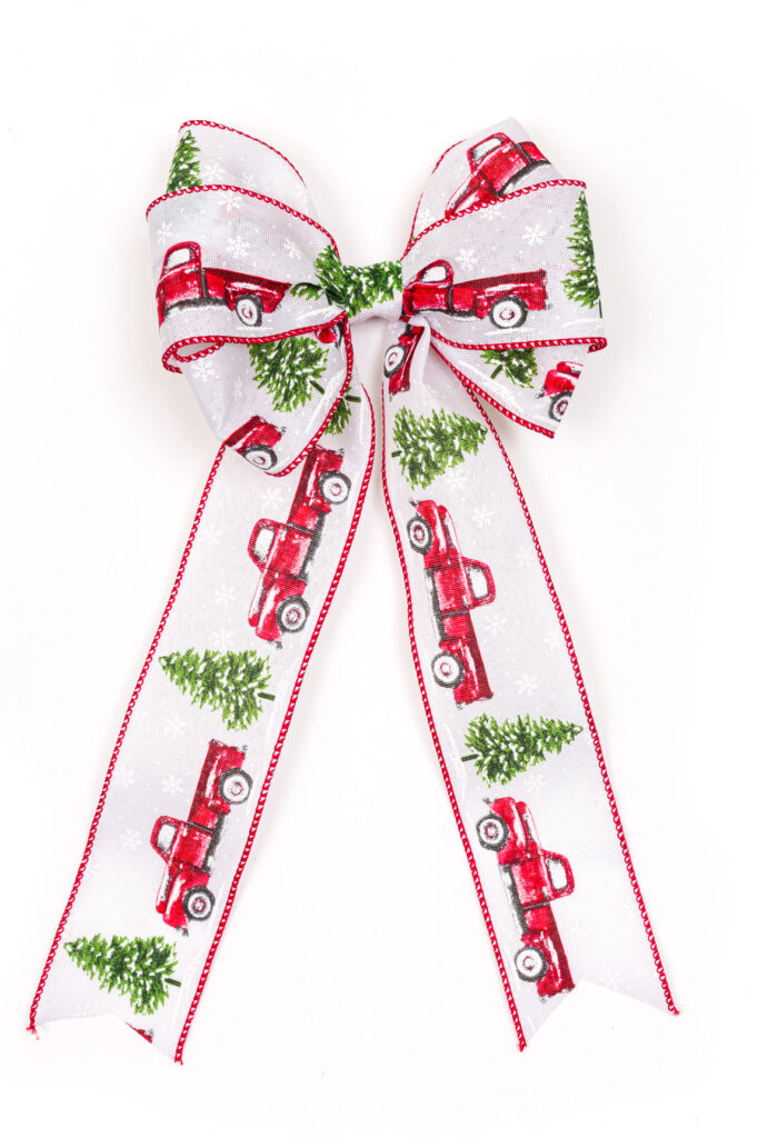 Ribbon bow with red trucks and trees on a table
