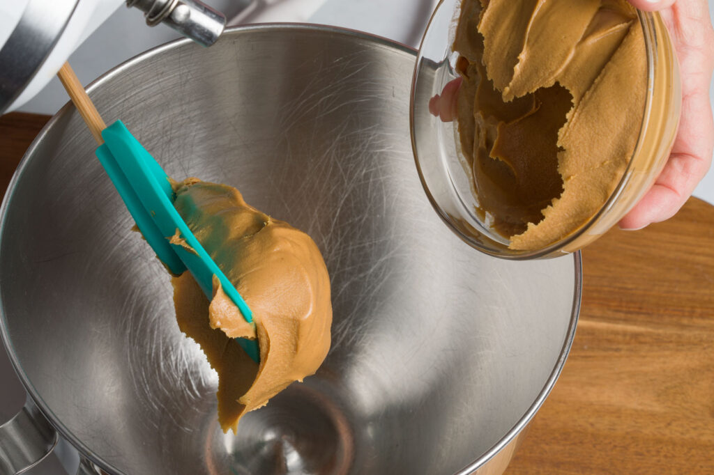 Place peanut butter in mixer bowl