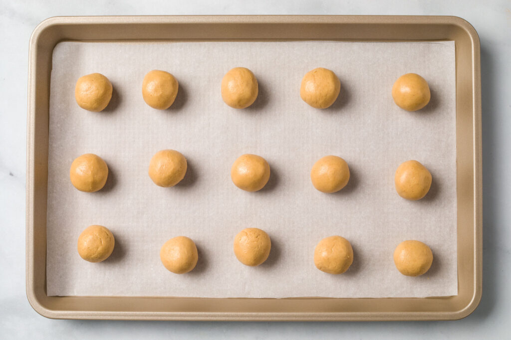 Buckeye peanut butter balls on a half sheet pan lined with parchment paper