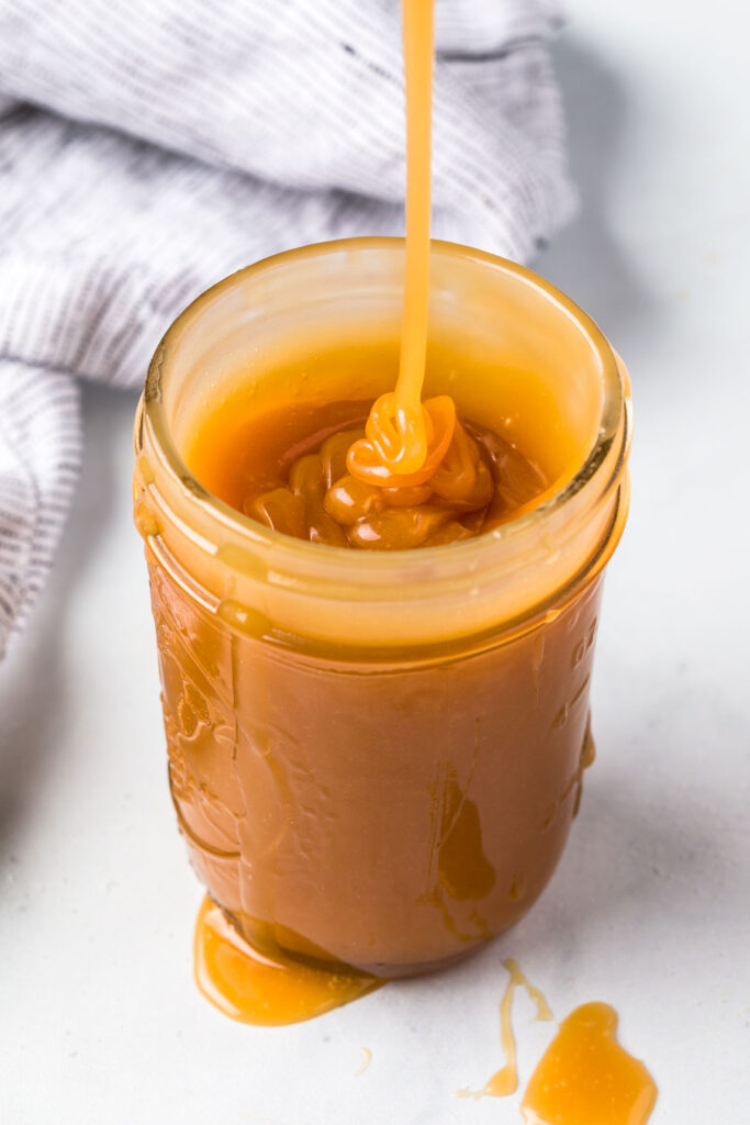 Pour homemade salted caramel sauce into a jar