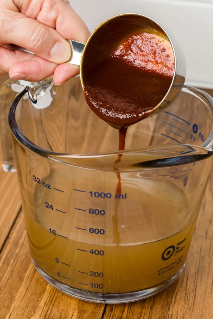 Adding barbecue sauce to chicken stock mixture