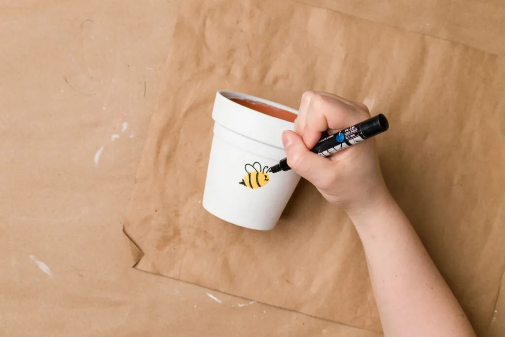 Painted flower pot with thumbprint bee face