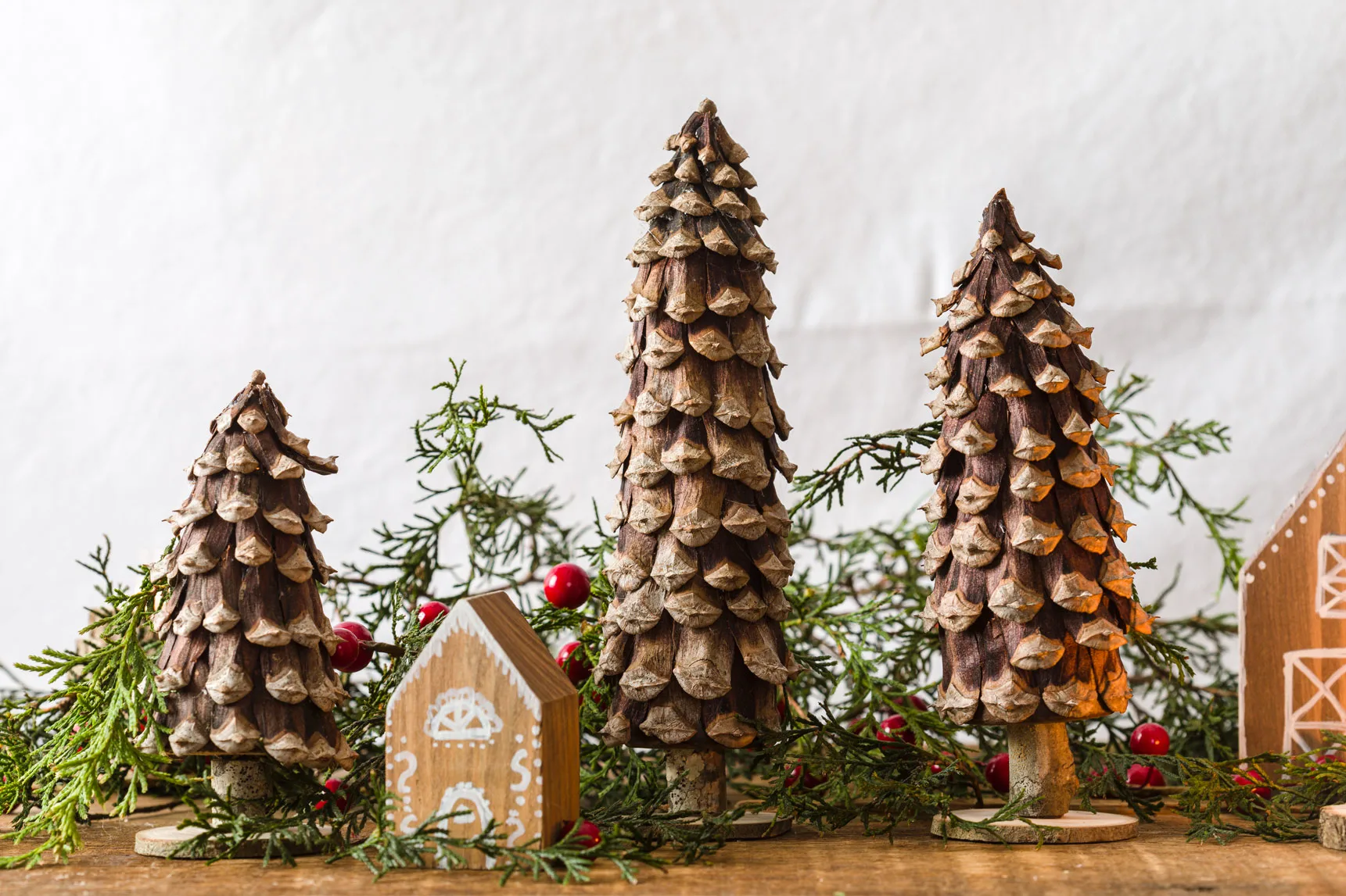 PIne Cone Christmas Trees on the wood table with DIY wood houses and cedar