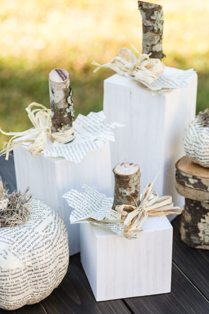 Finish white wooden pumpkins on a table with book page pumpkins