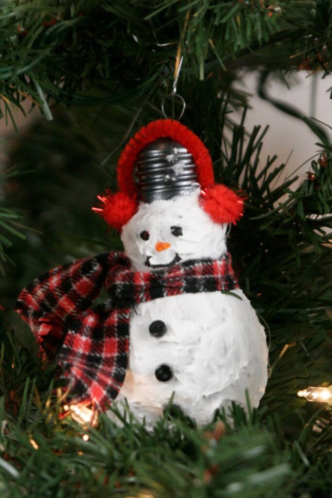 DIY snowman with a plaid scarf hanging on a tree