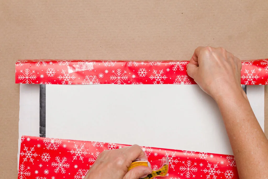 Adding three pieces of double-sided tape along the inside of the overlap on the bottom of the gift box