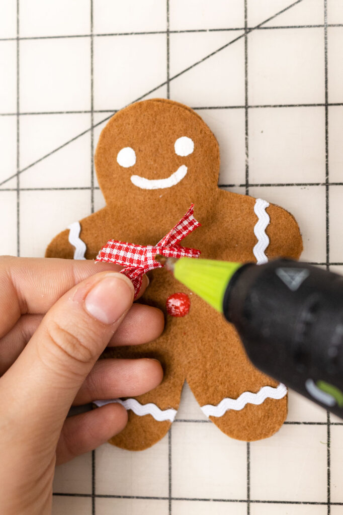 Gluing the ribbon bow tie to the gingerbread man