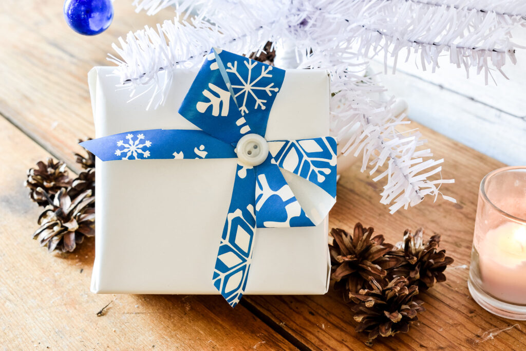 Blue and white gift wrapping with a button center under the Christmas tree 