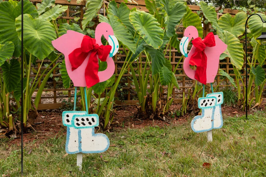 DIY Flamingos with snow boots and red ribbons in the yard