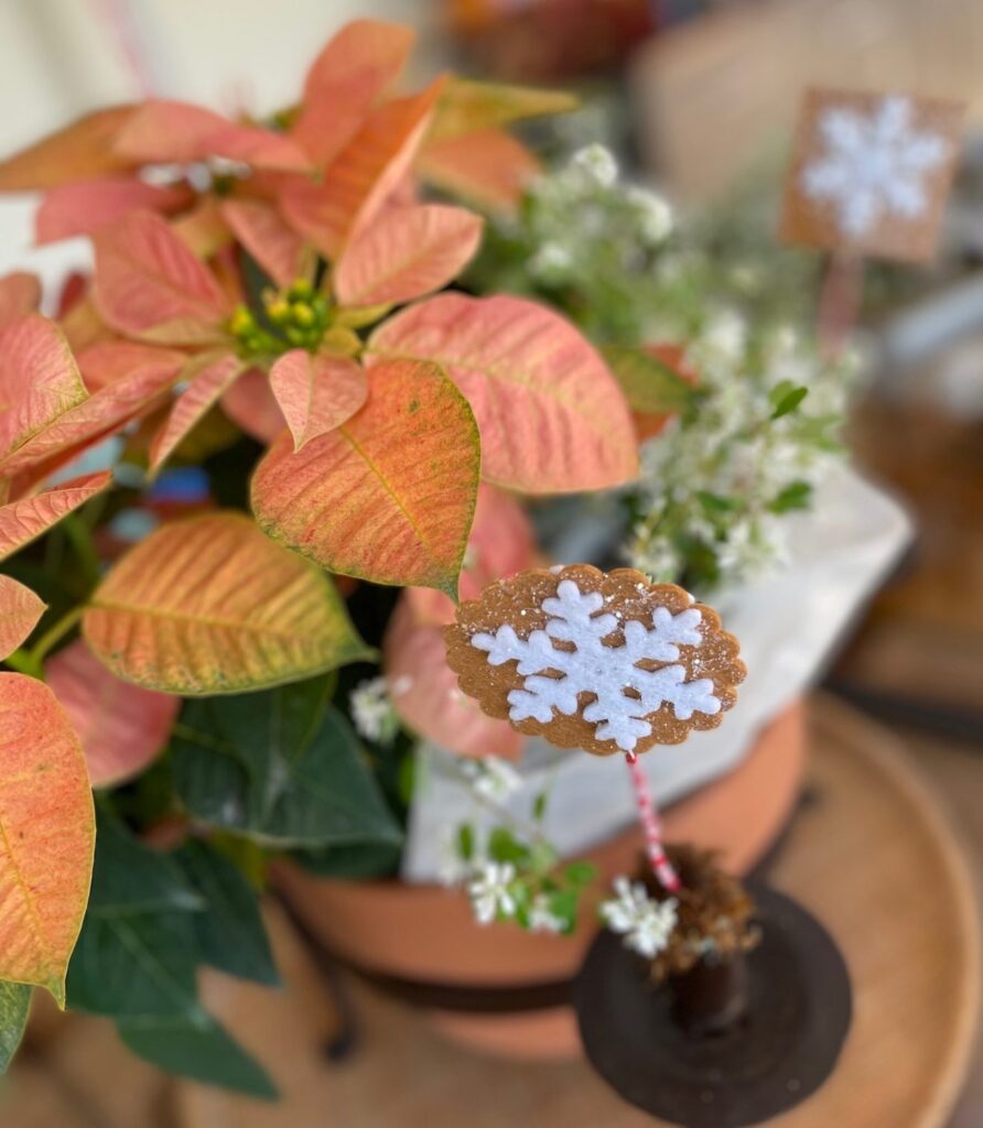 Christmas floral arrangement with gingerbread floral picks on a table on the porch
