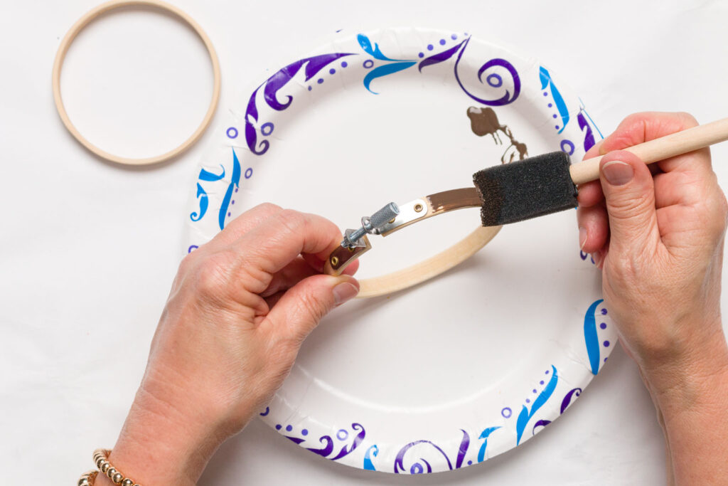 staining the outer ring of the embroidery hoop with with a sponge brush