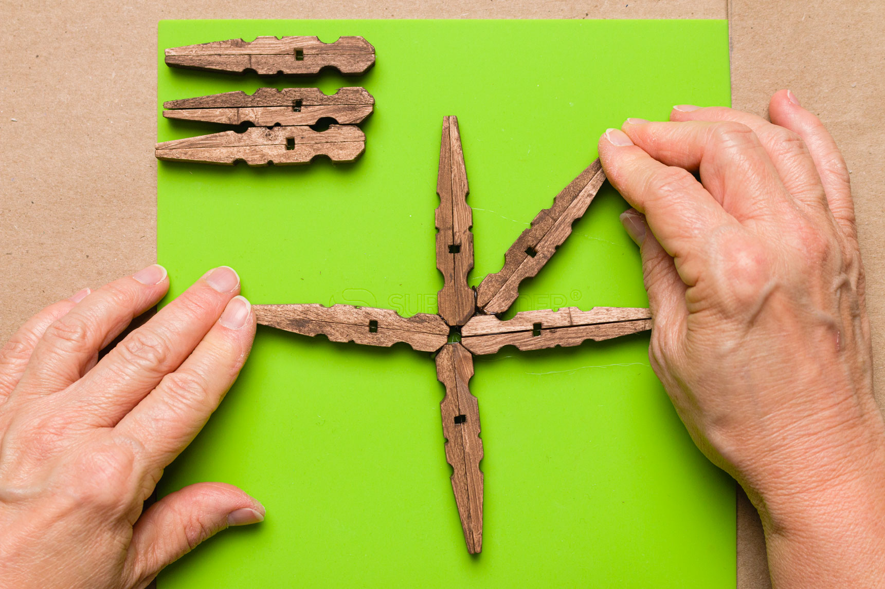 Gluing a clothespin pair between the clothespins in the cross formation 