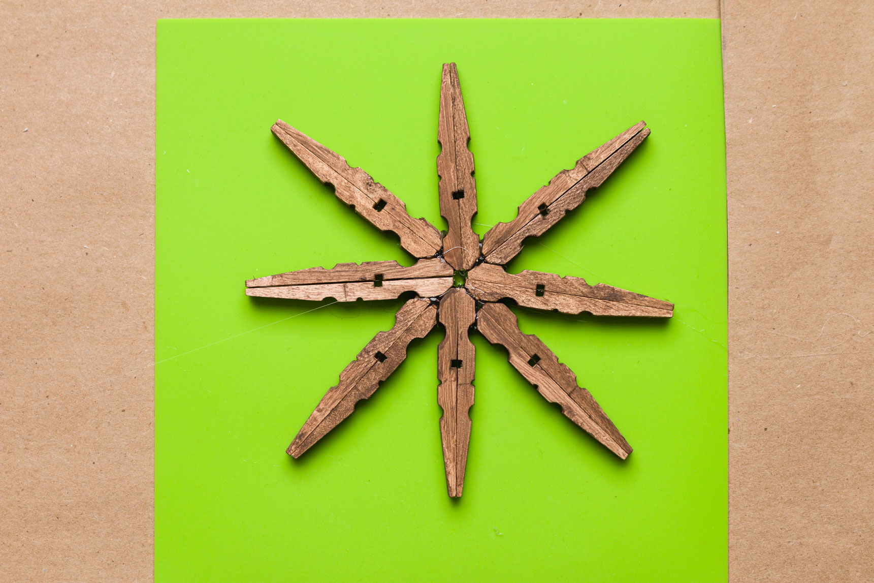 Basic clothespin Snowflake glued and ready for decorating on a silicone mat 