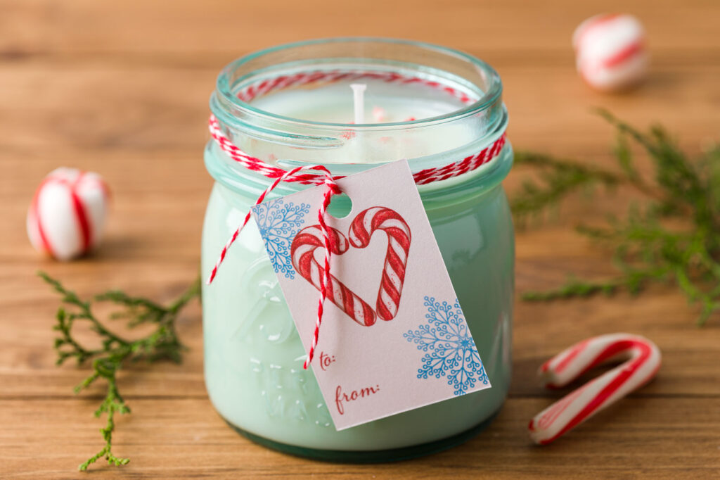 handmade peppermint candle with a gift tag and baker's twine on a wood table