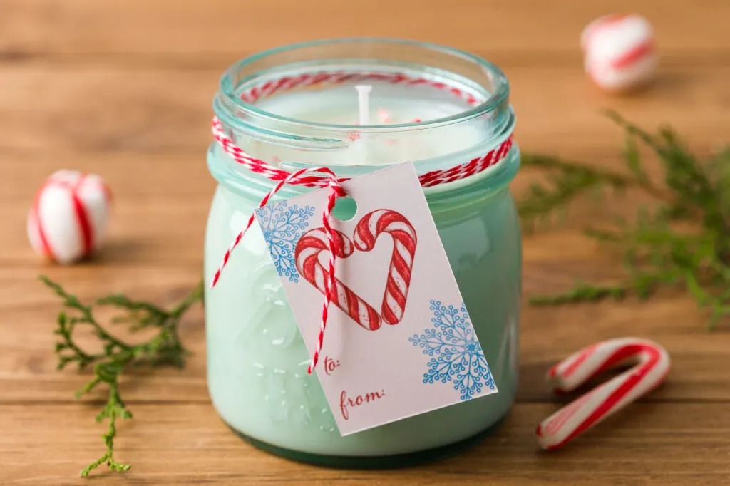 Handmade Candle handmade peppermint candle with a gift tag and baker's twine on a wood table