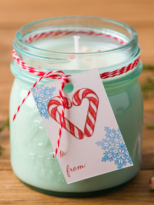 handmade peppermint candle with a gift tag and baker's twine on a wood table