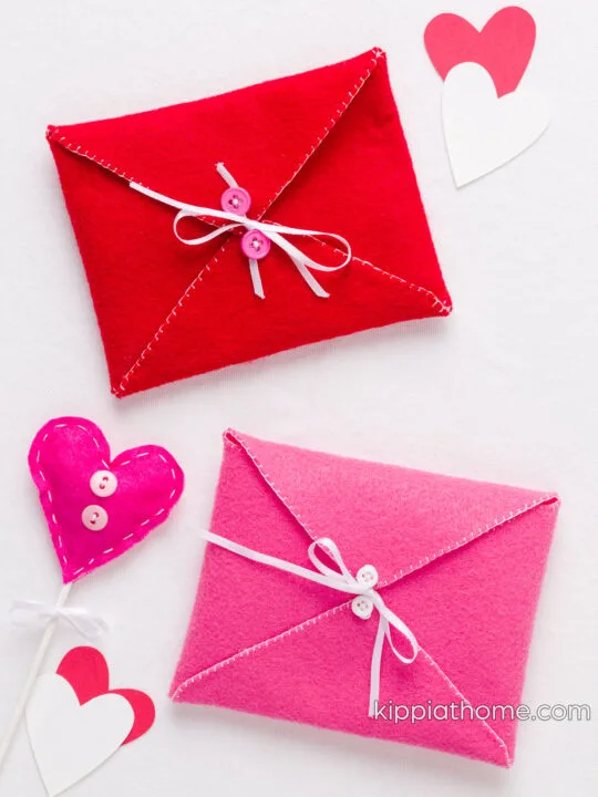 Pink and red envelopes tied closed with ribbon in a bow