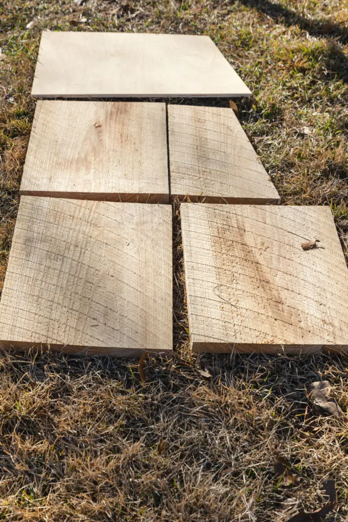 Cypress lumber cut for the front and back, and chamber divider sitting on the ground 