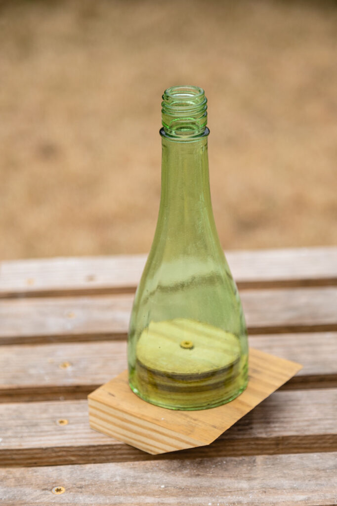 Cut off bottle sitting over the wooden bottle plug