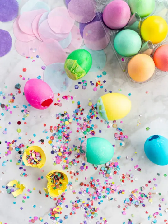 Colorful Dyed eggs, some eggs smashed with confetti and glitter scattered about