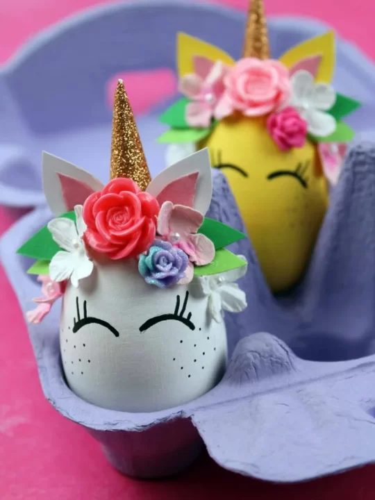 Unicorn Easter Eggs in a purple egg crate on a hot pink tablecloth 