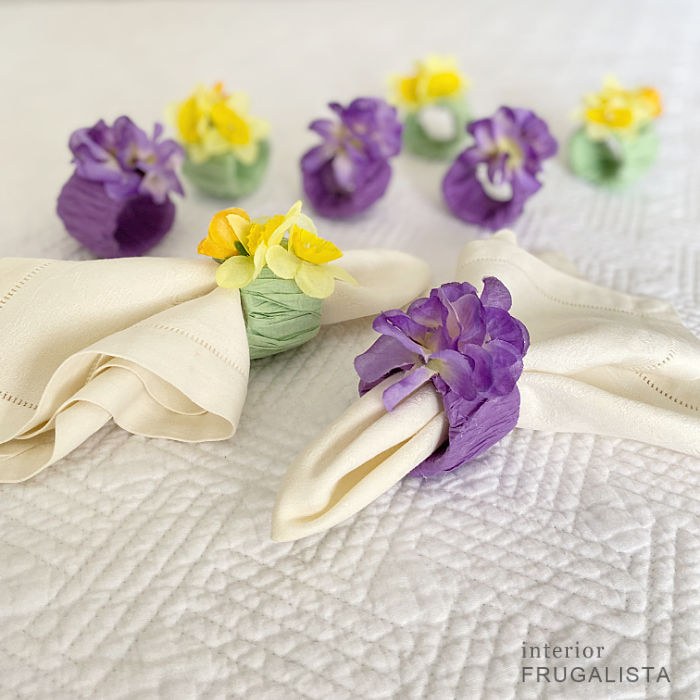 Purple and yellow cardboard napkin rings around napkins on a table