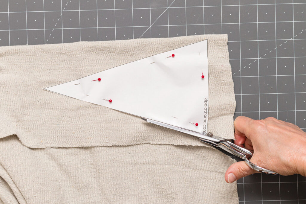 Cutting around the carrot pattern pinned to drop cloth on a cutting mat