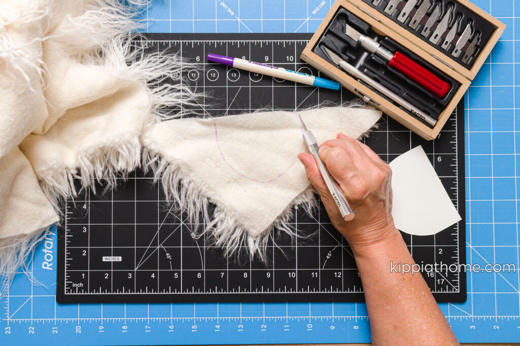 Using a craft knife to cut the faux fur on a cutting mat