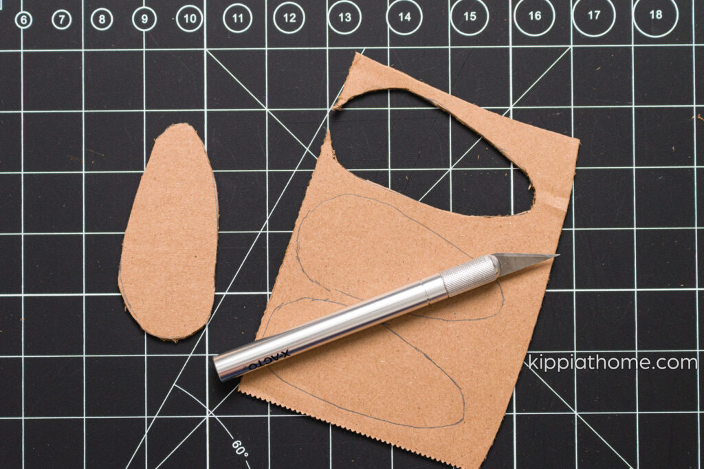 Craft knife and cardboard cut out on a cutting mat