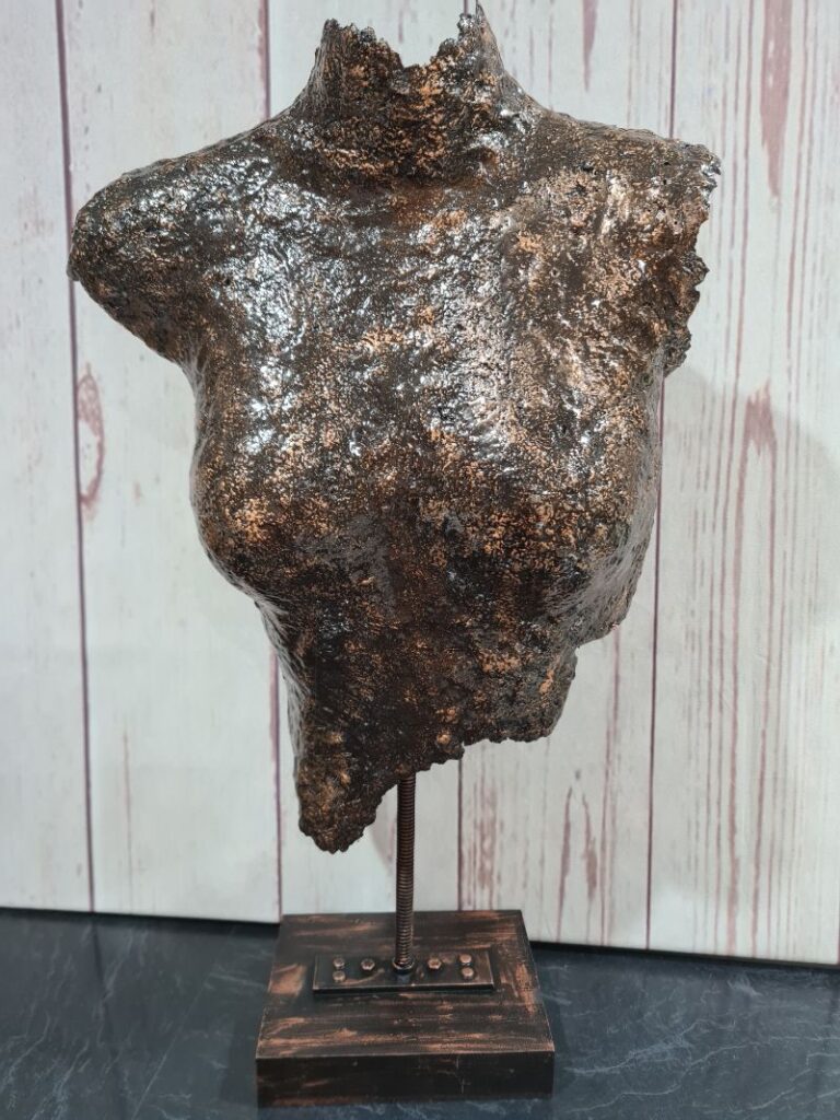 Bronze bust on a stand sitting on a table