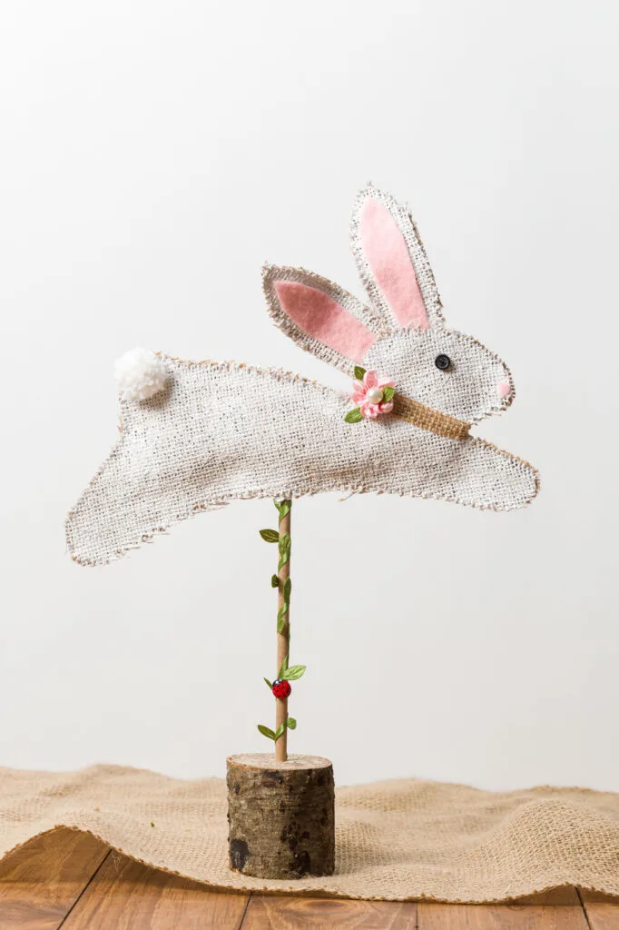 Bunny on a stand on a table with a burlap runner