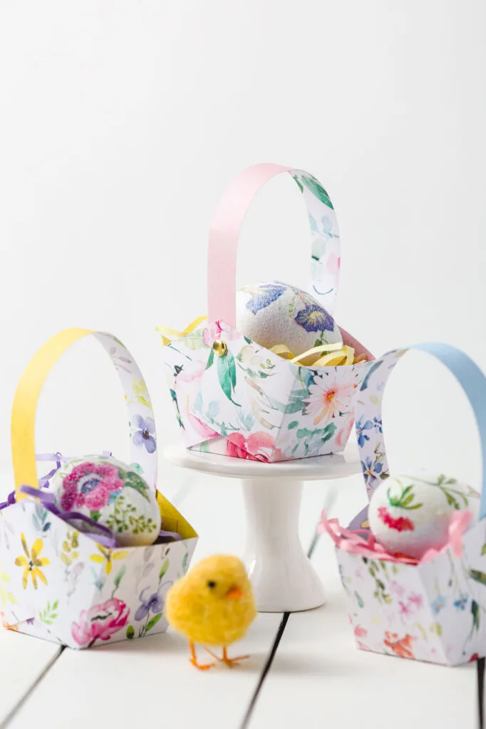 Three Easter Baskets with Easter grass and a decoupage egg on a table